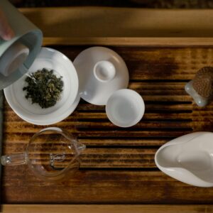 Elegant setup of a traditional tea ceremony on a wooden board with porcelain ware.