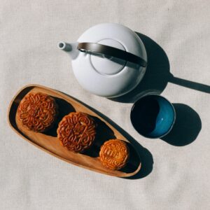 Overhead view of mooncakes with teapot and cup, perfect for Mid-Autumn Festival celebration.