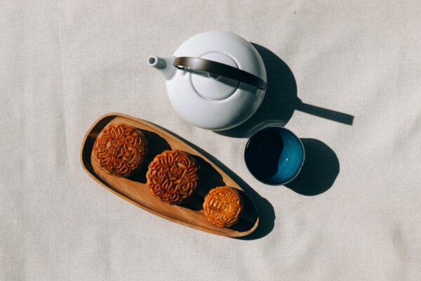 Overhead view of mooncakes with teapot and cup, perfect for Mid-Autumn Festival celebration.